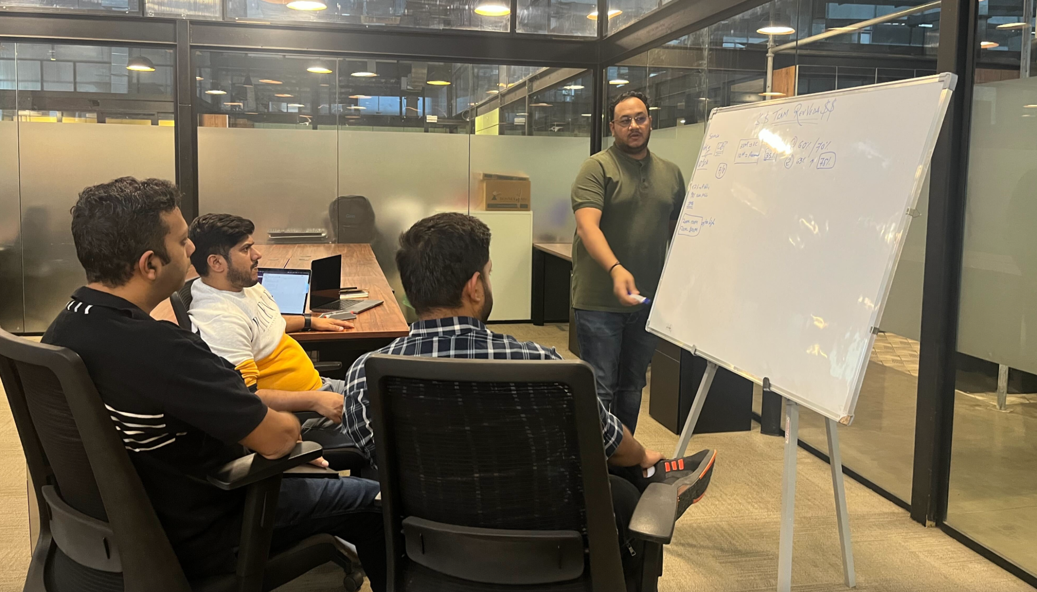 Team planning session - developers and engineers strategizing and drafting execution plans around a conference table during the hackathon