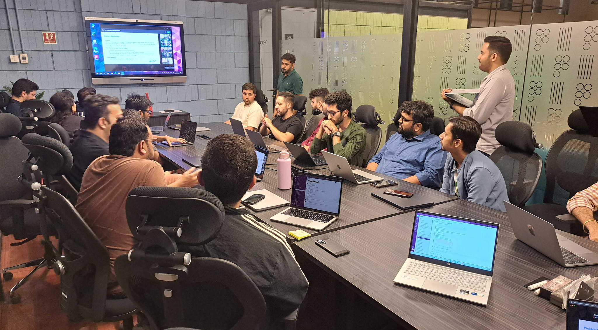 Hackathon team presenting their solution to judges - engineers demonstrating their innovative project with slides and live demo during the final presentation