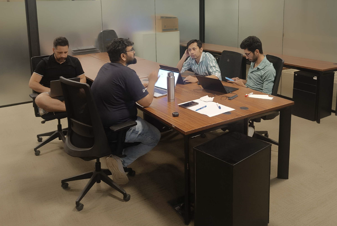 Team planning session - developers and engineers strategizing and drafting execution plans around a conference table during the hackathon